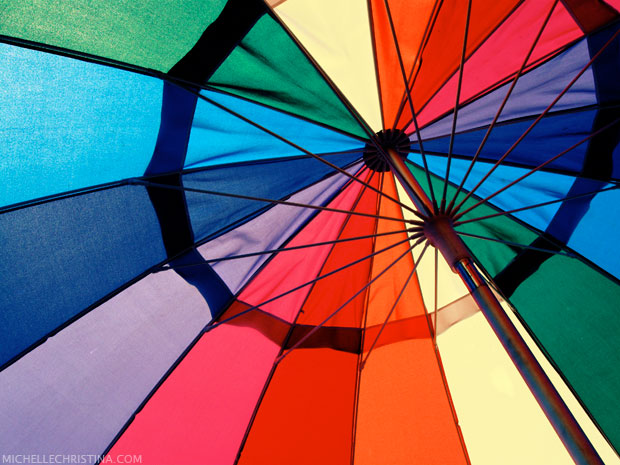 colorful beach umbrella photo by michelle christina